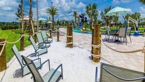 Un espace aménagé au bord de la piscine, avec des chaises longues, une piscine, des palmiers et un ciel dégagé.
