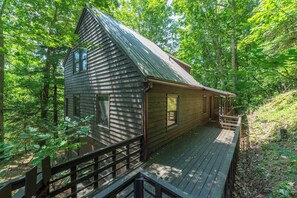 A cabin with a sloped roof, a deck, and a wooden railing. - 2 mins to Ski! Hot Tub+Fire Pit, Fireplace, Grill! (Mars Hill)