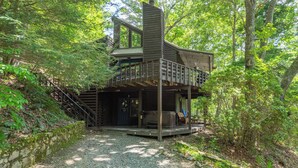A cabin with a wooden deck, a hot tub, and a staircase leading to a second level. - Come Ski Hatley Pointe! Hot Tub+Fire Pit, Fireplace,WiFi, Pet Friendly!  (Mars Hill)