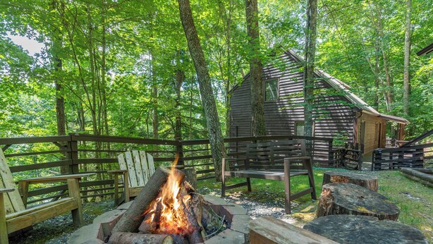 A rustic cabin with a fire pit in a forest setting. - Come Ski Hatley Pointe! Hot Tub+Fire Pit, Fireplace,WiFi, Pet Friendly!  (Mars Hill)