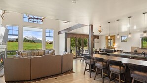 A spacious living area with a large sofa, a dining table, and a bar area.