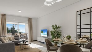A modern living room with a sofa, chairs, a coffee table, and a dining area with a table set for four.