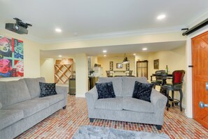 Relax in this inviting living space with two sofas, a dining table, and a projector for entertainment.