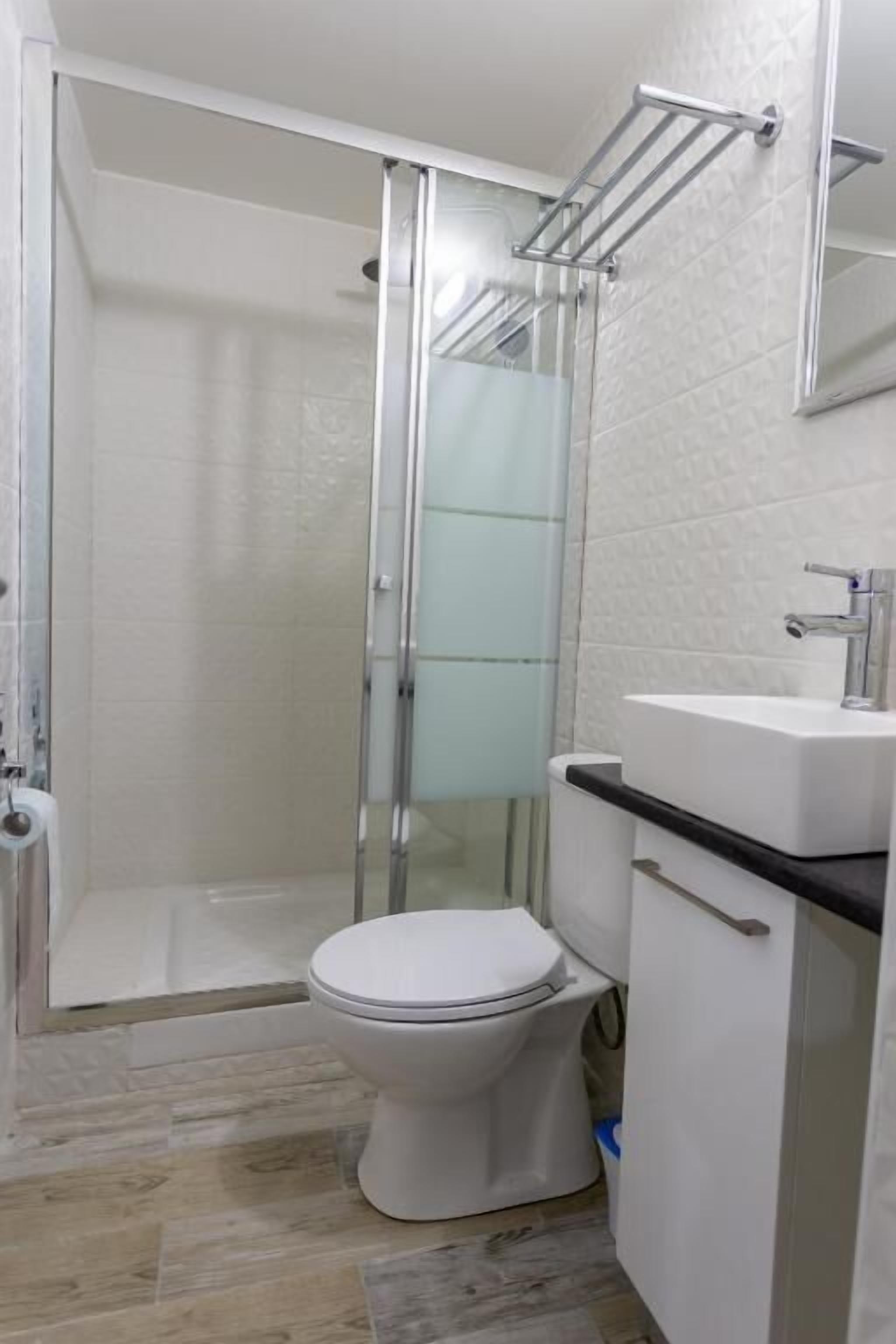 Un baño con ducha, inodoro y lavamanos.