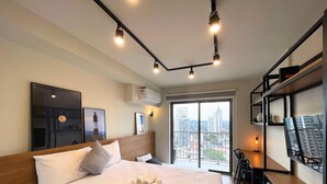 Una habitación de hotel con una cama grande, un escritorio y vistas de la ciudad a través de la ventana.