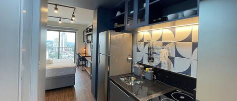 A modern kitchen with a built-in stove, a refrigerator, and a dining area with a view.