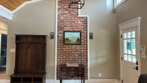 A room with a wooden bench, a wall-mounted picture, a door with a window, and a ceiling with exposed beams. - Recently updated Park Street Cottage with garage in Downtown Greeneville, TN. (Greeneville)