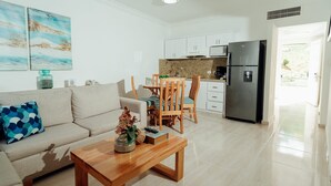 Una sala de estar moderna con sofá, mesa de centro y comedor.