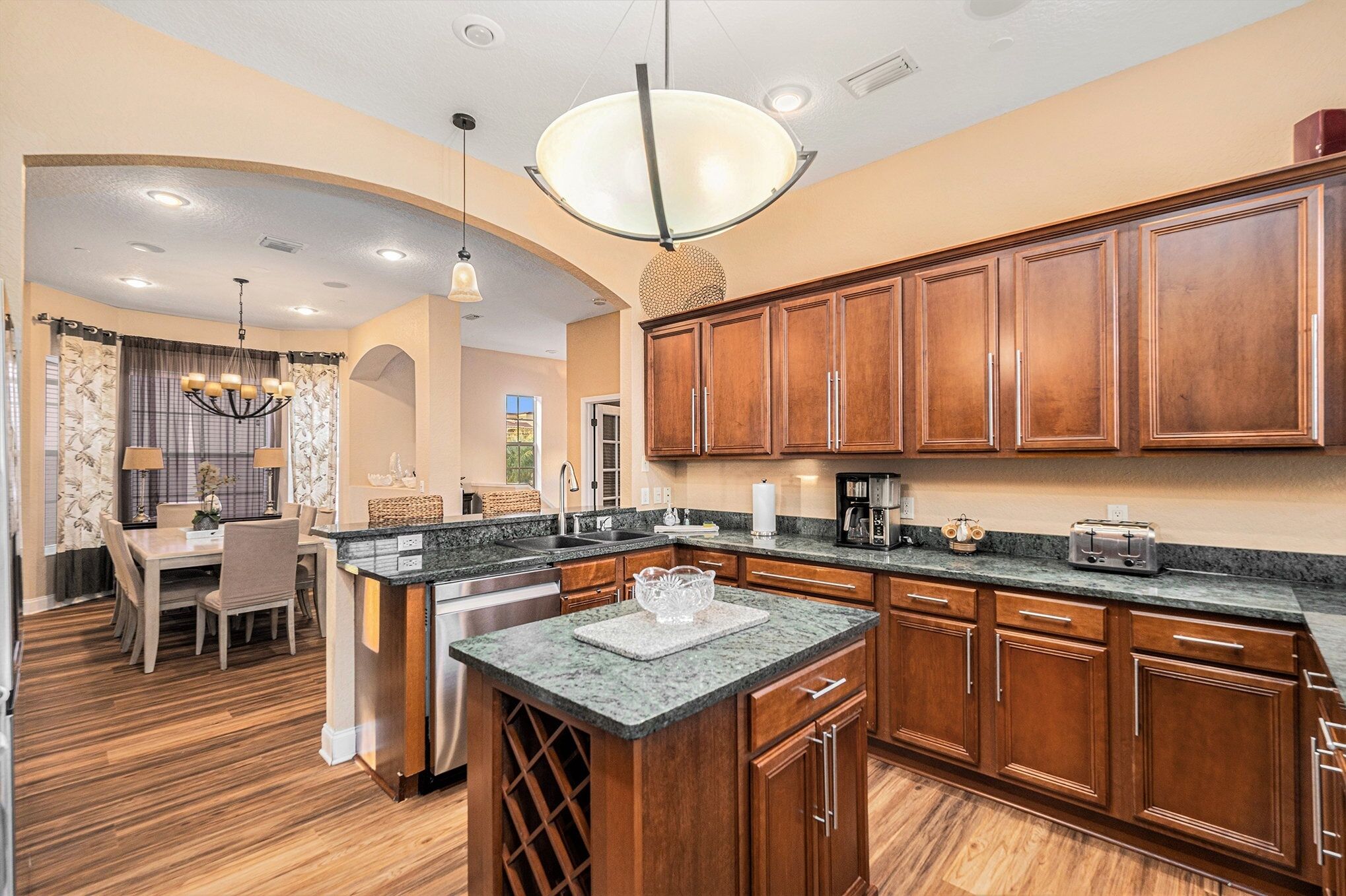 A kitchen with wooden cabinets, granite countertops, and a central island.