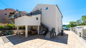 A two-story building with a balcony, a staircase, and a covered outdoor seating area. - Awesome apartment in Turanj with WiFi (Turanj)