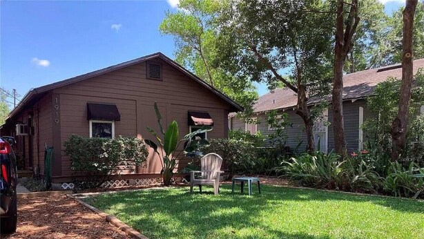 Une maison brune d’un seul étage, dotée d’une pelouse bien entretenue et d’un patio avec une chaise et une table.