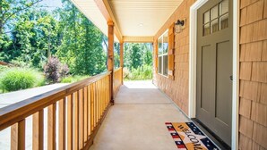 A covered porch with a wooden railing, a welcome mat, and a door. - The Clemson Cottage - 3.6 mi. to Memorial Stadium (Seneca)