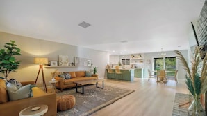 A spacious living room with a sofa, coffee table, and a dining area with chairs.
