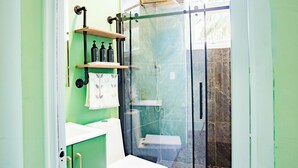 Ein Badezimmer mit Duschkabine, Toilette und Waschbecken.