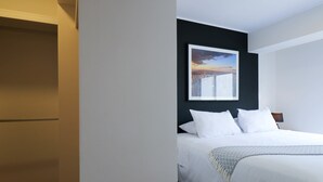 A hotel room with a bed, a nightstand, and a framed picture on the wall. - Wynwood Residencial in Miraflores (Lima)