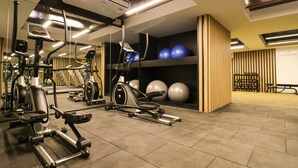 A gym with various exercise machines, a wall-mounted air conditioning unit, and exercise balls. - Wynwood Residencial in Miraflores (Lima)