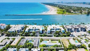 Luchtbeeld van een kustresort met meerdere gebouwen, een strand en een pier.