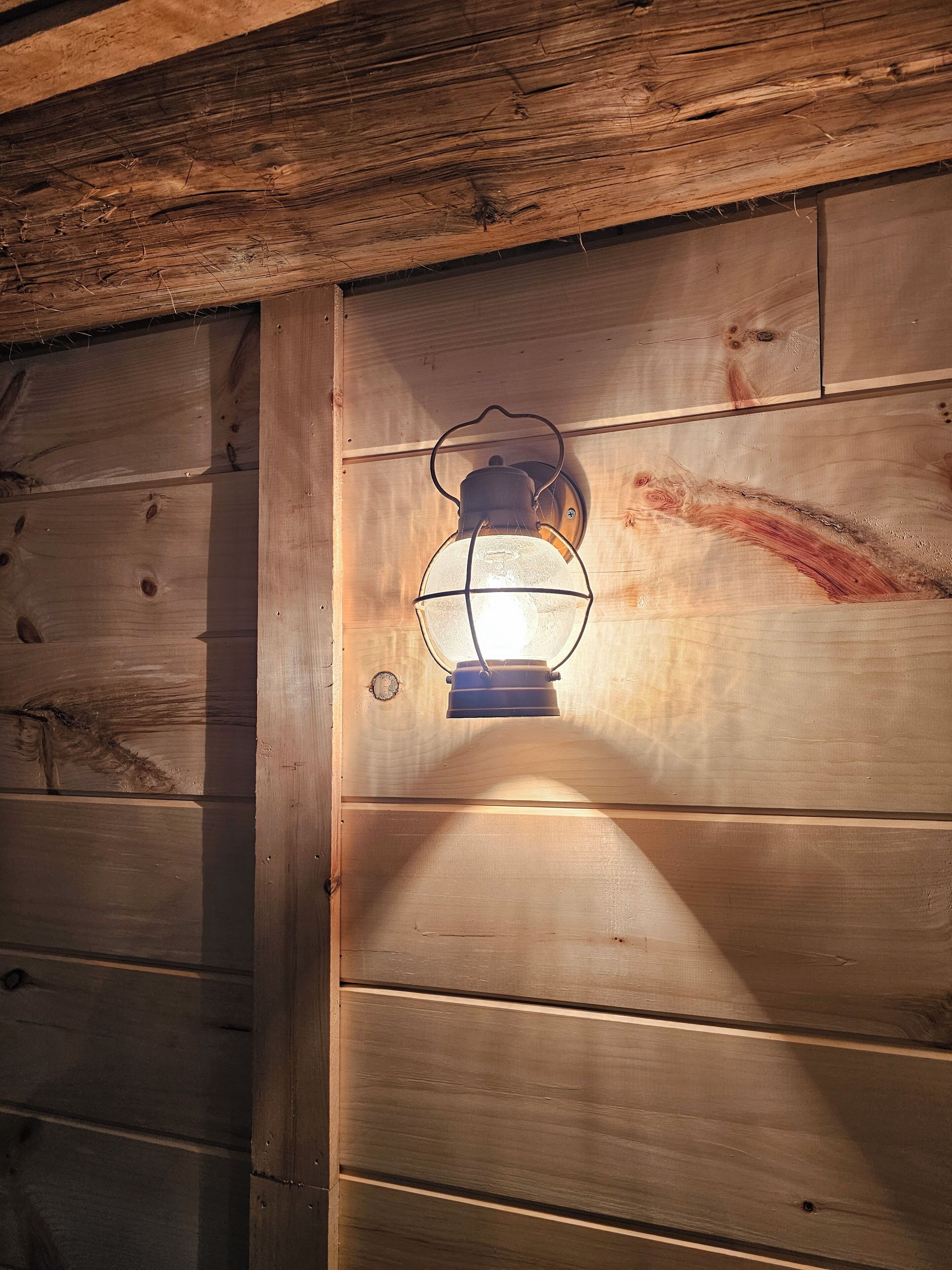 A lantern mounted on a wooden wall with horizontal planks.