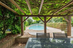 A covered outdoor area with a pool, wooden pergola, and seating. - Champ de Gain: family home with swimming pool 10 minutes from Futuroscope (Saint-Georges-lès-Baillargeaux)
