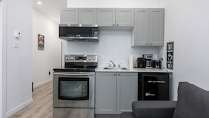 A compact kitchen with a built-in oven, microwave, and coffee maker.