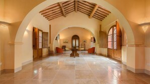 A spacious hall with a high ceiling and arched ceilings, featuring a central table and chairs. - Villa Boschetto By MMega (Montepulciano)