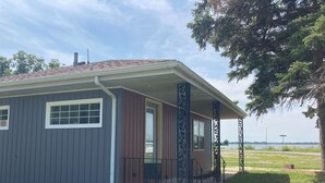 Una casita con porche, chimenea y vista al lago.