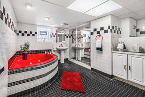 Tina de hidromasaje, toallas, papel de baño 