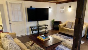 A living room with a sofa, coffee table, TV, and fireplace.