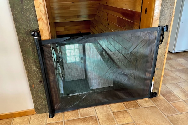 Retractable baby gate at top of stairs