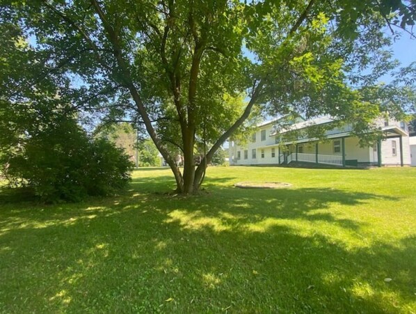 A large, two-story house with a covered porch and a well-maintained lawn.