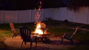 An outdoor patio with a fire pit surrounded by chairs and a table. - Zojo_ Lovely House Close TO Disney (Clermont)