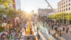 A busy urban street scene with pedestrians, buildings, and a prominent yellow structure in the center. - #202_Downtown's Exquisite Luxury Studio (Montreal)
