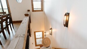 En trätrappa med ett räcke, en träbänk och en väggmonterad lampa.