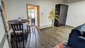 Un espacio habitable compacto con comedor, sofá y armario.