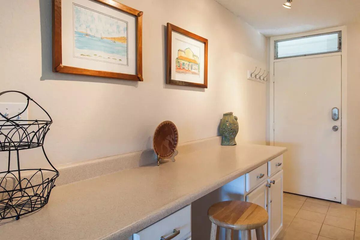 A kitchen with a countertop, a sink, a cabinet, and a door.
