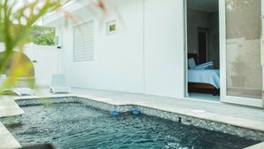 A modern house with a swimming pool, a bedroom with a bed, and a sliding glass door. - Stay Near Isabela’s Best Beaches! Tropical Home w/ Pool & Space for Groups! (isabela)