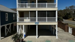 A two-story building with a balcony on the upper floor, a garage in the front, and a sign with a number. - Heart of Ocean Drive just one block to the Beach and Main Street  (North Myrtle Beach)