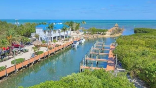 Un hôtel situé au bord de l’eau, doté d’un quai, d’un bateau et offrant une vue dégagée sur l’océan.