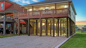 A two-story building with a balcony, wooden deck, and a covered outdoor area. - Steps to Sand + Gulf Views, 2 Kings, Firepit, Dog Friendly (Crystal Beach)
