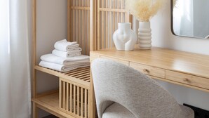 A neatly organized room with a wooden desk, a chair, and a shelf with folded towels. - Meraki Suites (2 Rooms) (Astorga)