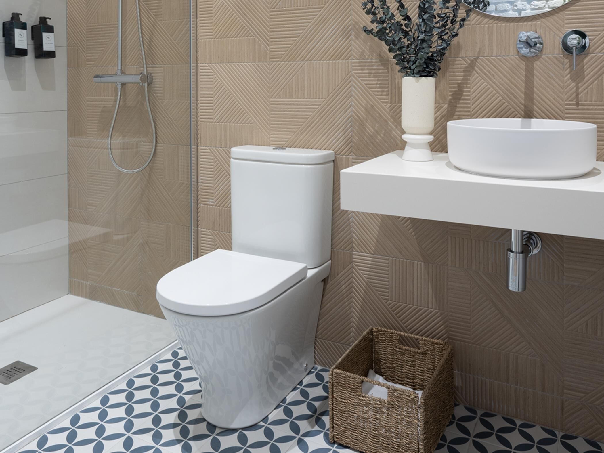 Un baño moderno con inodoro blanco, lavamanos y ducha.