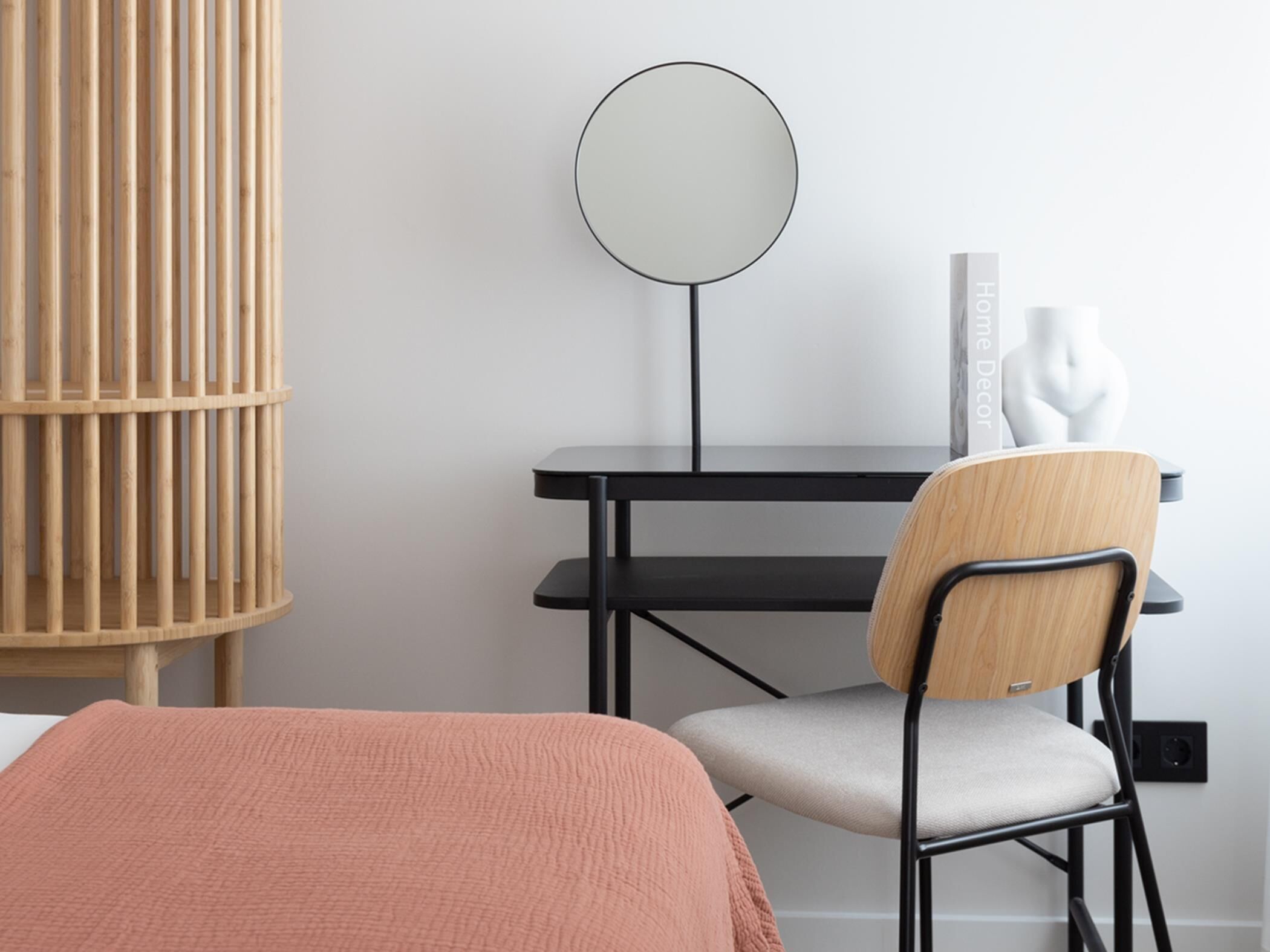 Un dormitorio con cama, escritorio, silla, espejo y estante en la pared.