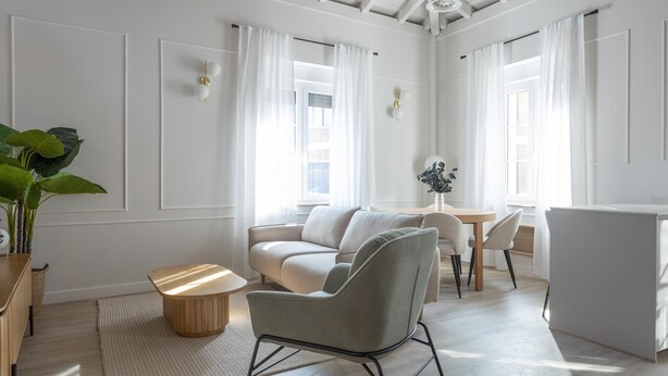 A modern living room with a sofa, chairs, a coffee table, and a dining area with a table and chairs. - Meraki Suites (2 Rooms) (Astorga)