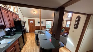 A kitchen with wooden cabinets, a black refrigerator, and a large island with a sink. - Wonderfully located near Bay Street and all the wonderful restaurants. Sauna! (Florence)