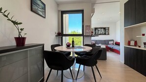 A modern kitchen with a dining area, a large window, and a view of the outdoors. - Apartment Oliva by Interhome (Rijeka)