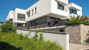 A modern two-story building with a flat roof, large windows, and a stone facade. - Apartment Oliva by Interhome (Rijeka)