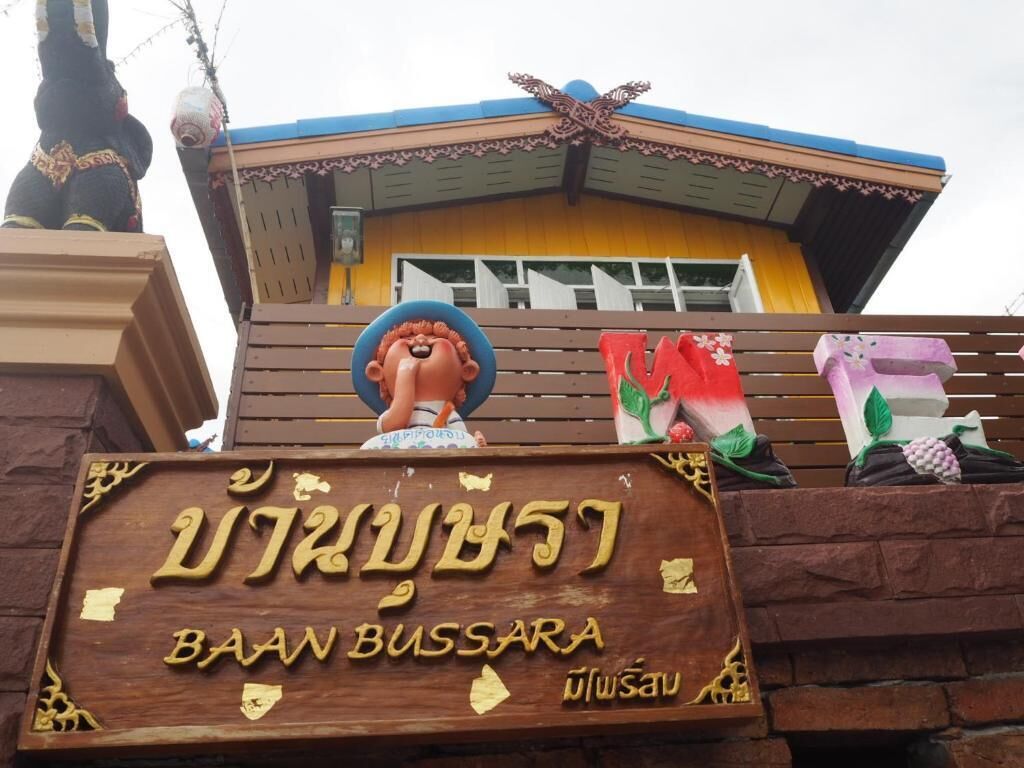 A wooden sign with Thai text and a logo, indicating a location named "BAAN BUSSARA".