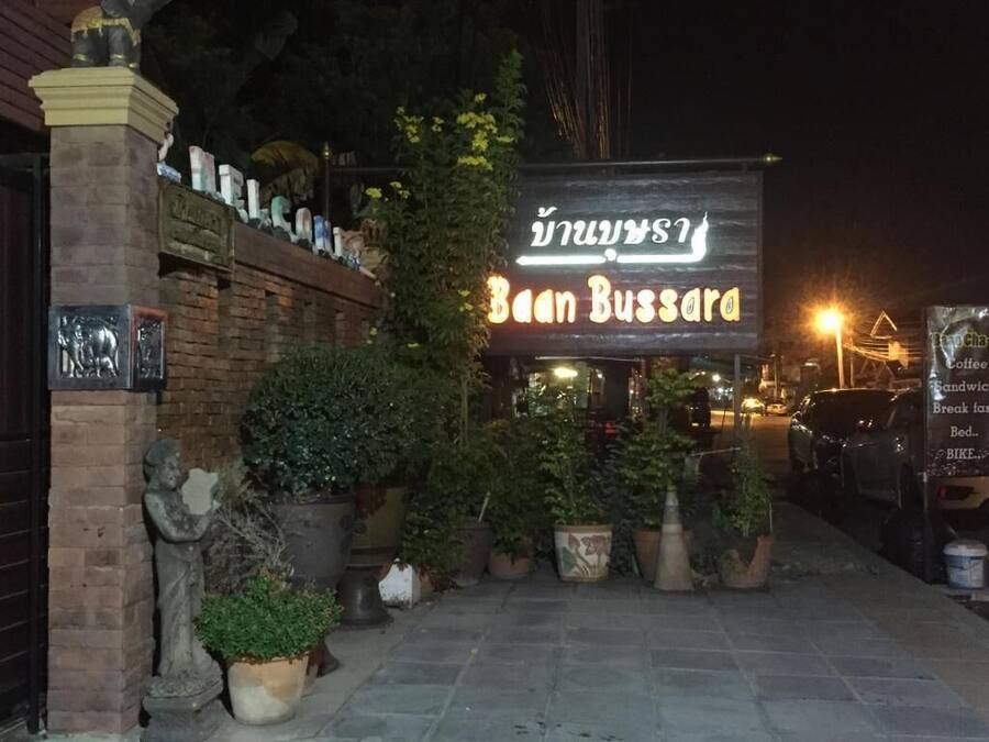 Exterior d'un restaurant anomenat "Baan Bussara" amb façana de maó, plantes en testos i un cartell.