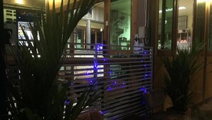 Un restaurant doté d’une clôture en bois, de lumières bleues et de plantes en pot.