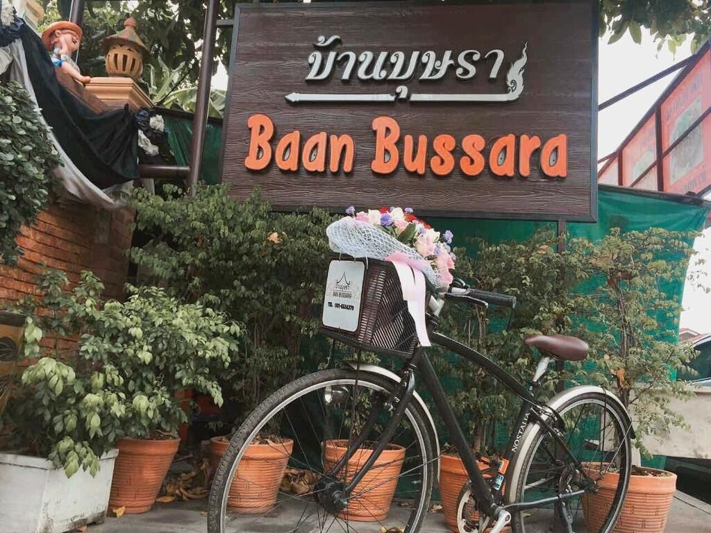 Ein Fahrrad vor einem Schild mit thailändischen Schriftzeichen.